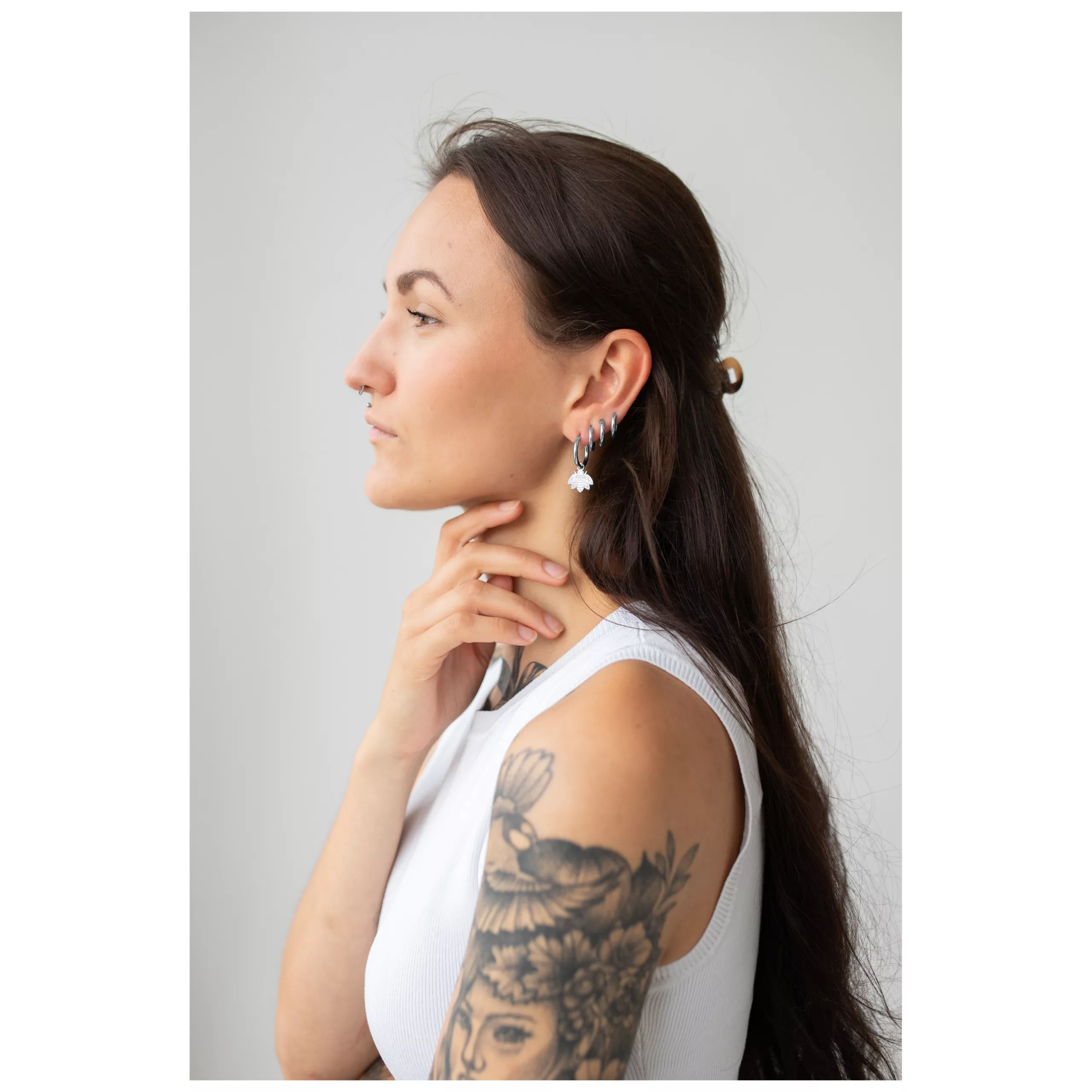 Frau mit langen Haaren trägt silberne und goldene Little Bee Hoops vor hellem Hintergrund