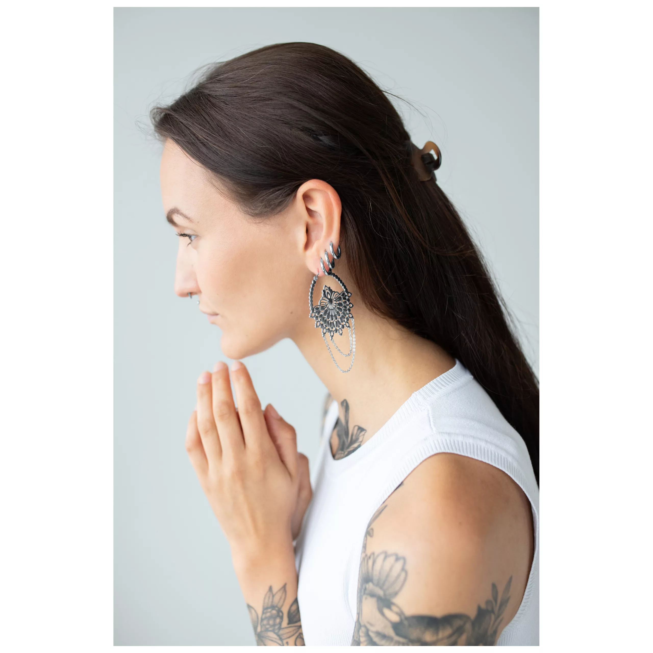 Frau mit langen, dunklen Haaren trägt große, silberne Rising Sun Hoops Ohrringe