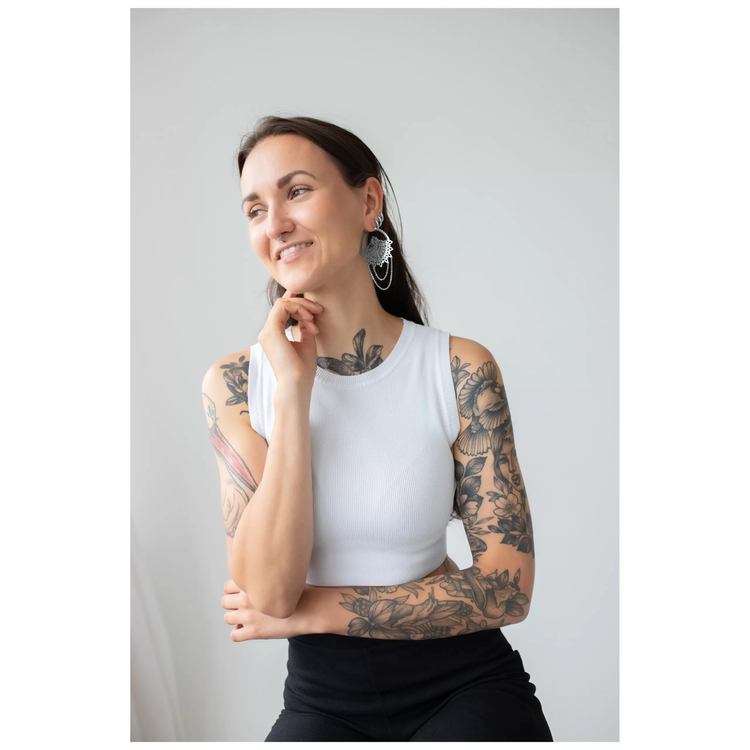 Frau mit silbernen Rising Sun Hoops Ohrringen, lächelnd, weißes Top