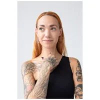 Frau mit tätowierten Armen trägt Mandala Hoops Ohrringe in Roségold