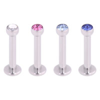 Vier silberne Labrets mit klaren, pinken und blauen Kristallen auf weißem Hintergrund