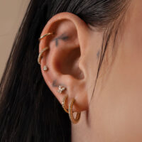 Goldener Moissanit Aufsatz im Ohr, glänzend auf Haut