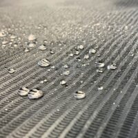 Nahaufnahme einer schwarzen, wasserdichten Abdeckrolle mit Wassertropfen