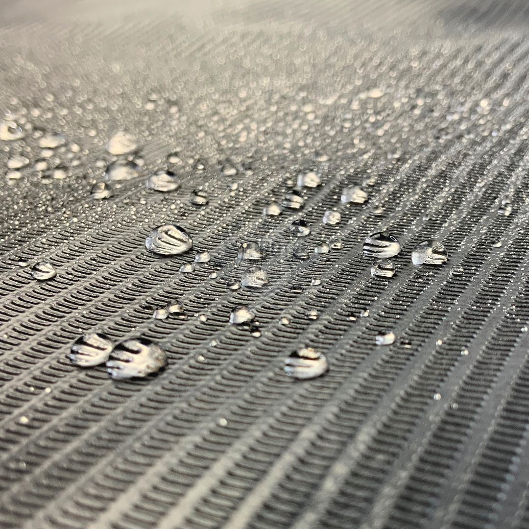 Nahaufnahme einer schwarzen, wasserdichten Abdeckrolle mit Wassertropfen