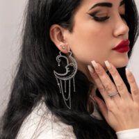 Frau mit silbernen Sun Moon Hoops, seitliches Profil, glatter Hintergrund